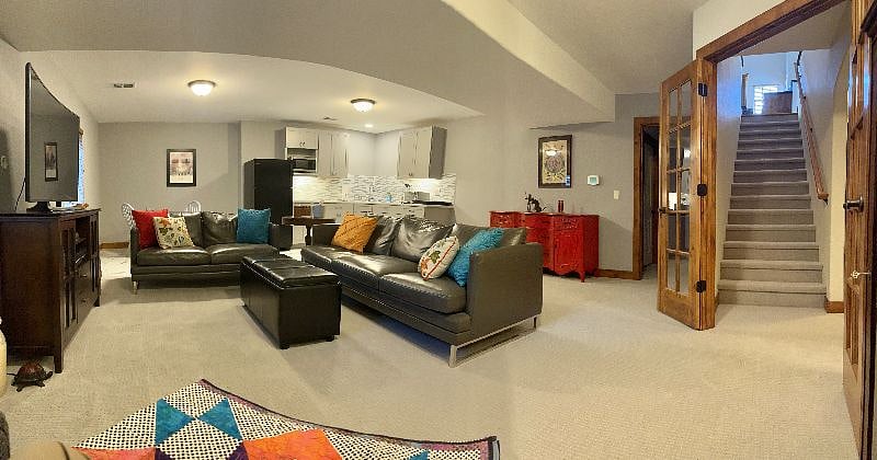 Living room area and kitchen at bottom of stairs lower level