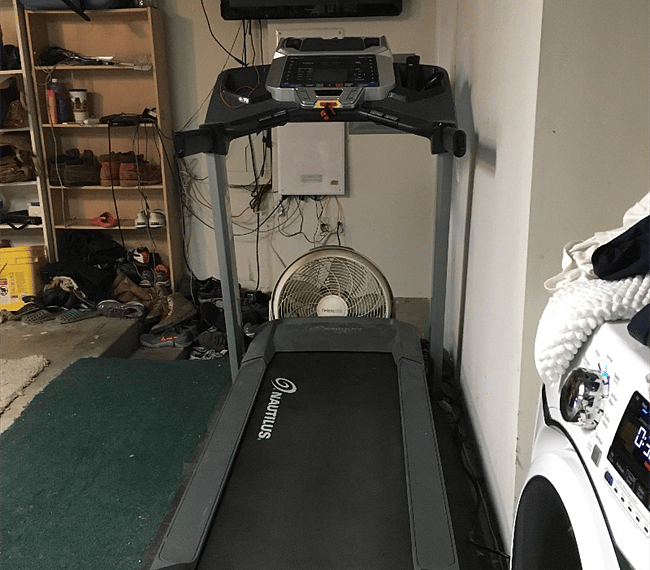 Treadmill with TV, TiVo, AppleTV, and headphone jack in the garage. There is an elliptical trainer with another TV on the opposite side.