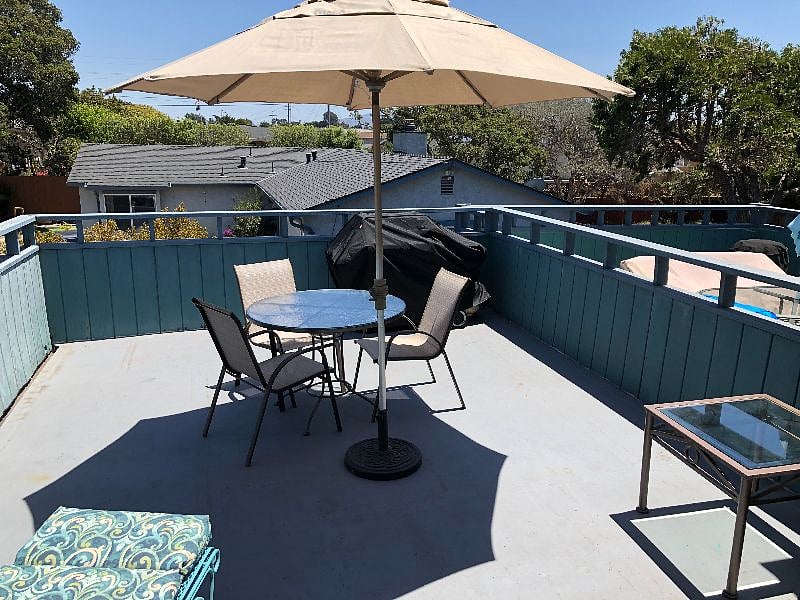 Umbrella and table for dining on the upper deck above the garage