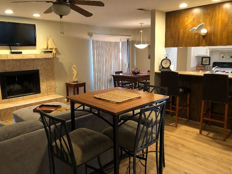 Open concept great room, bar with two bar stools, dining room with antique table and kitchen.