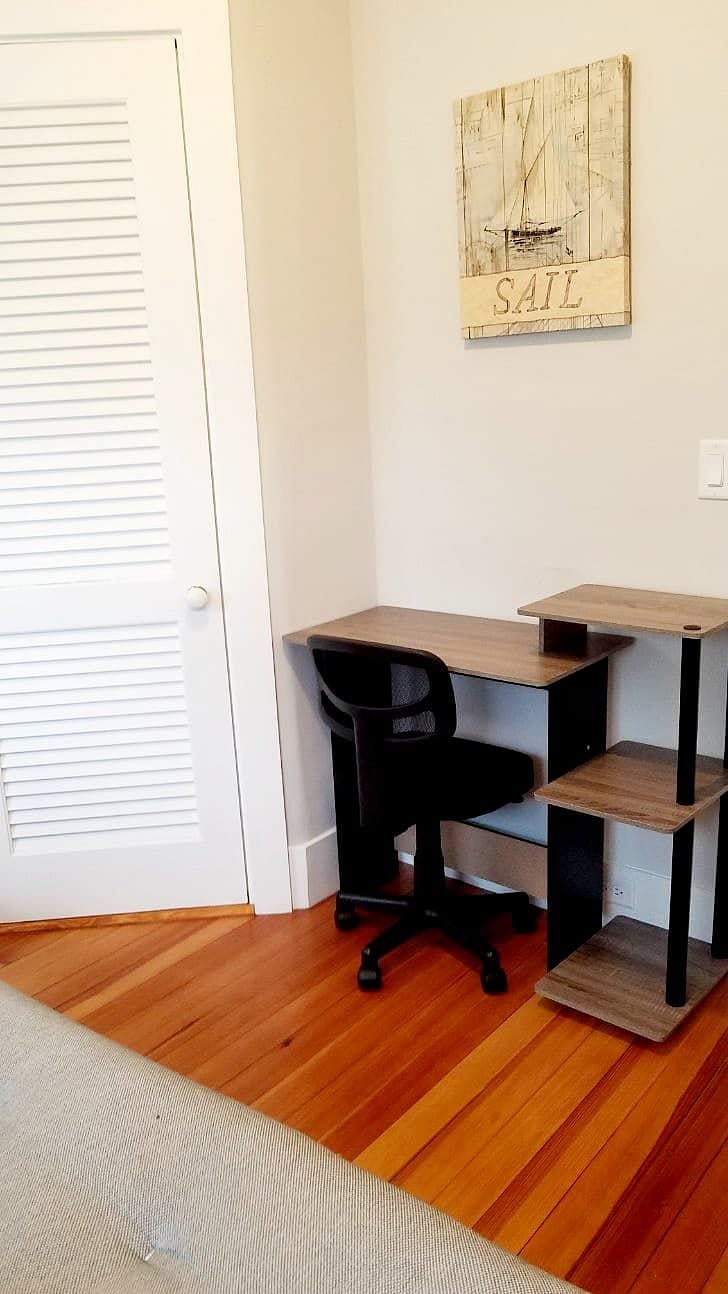 Second bedroom with queen sized futon, closet, and small desk.