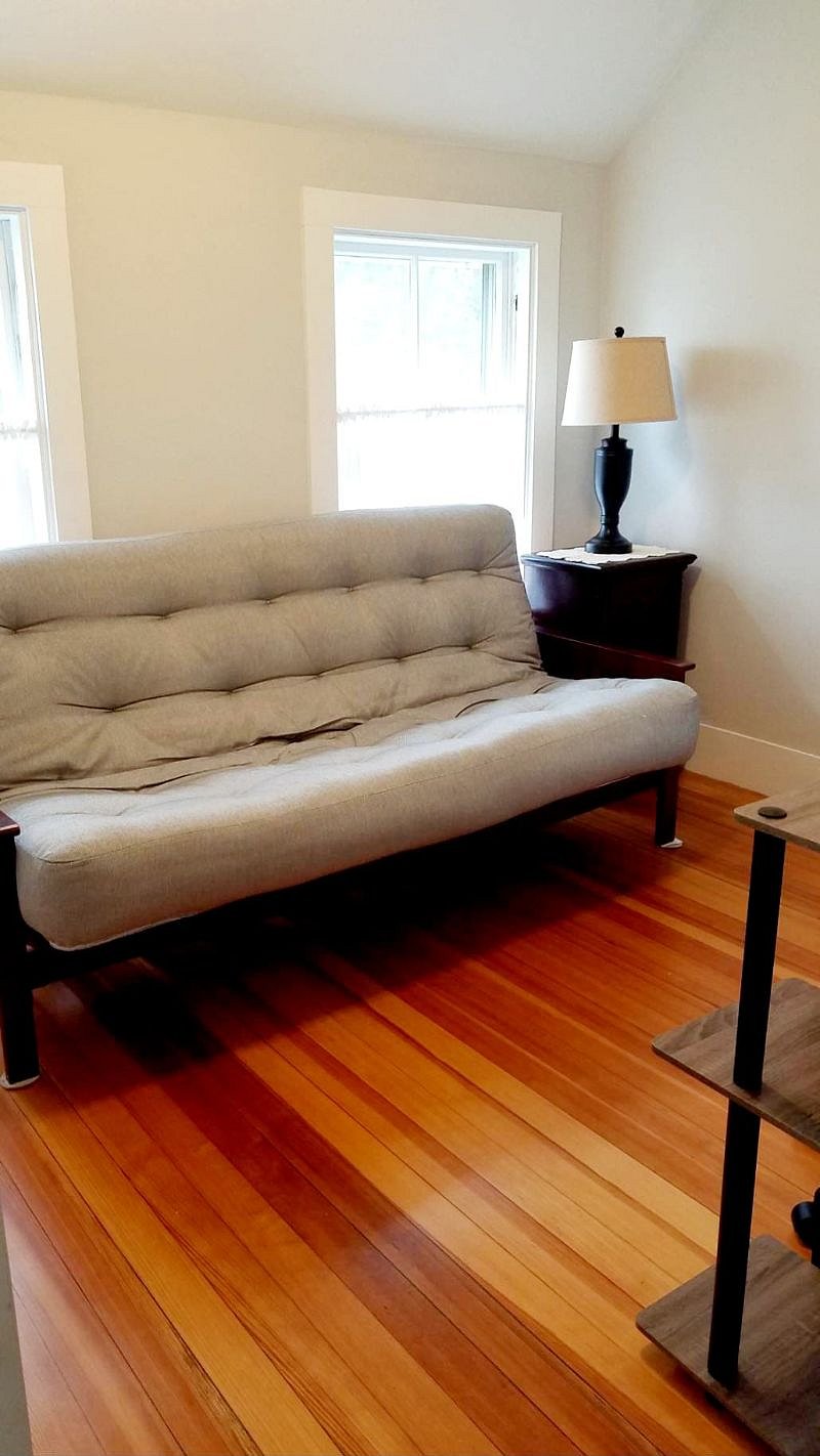 Second bedroom with queen sized futon, closet, and small desk.
