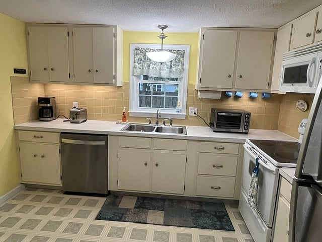 Spacious and full applianced kitchen with lots of counter space and full size refrigerator and stove.