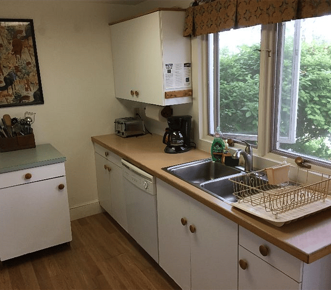 Kitchen and windows to view of river. Automatic dish-washer, toaster, drip coffee maker, and coffee bean grinder