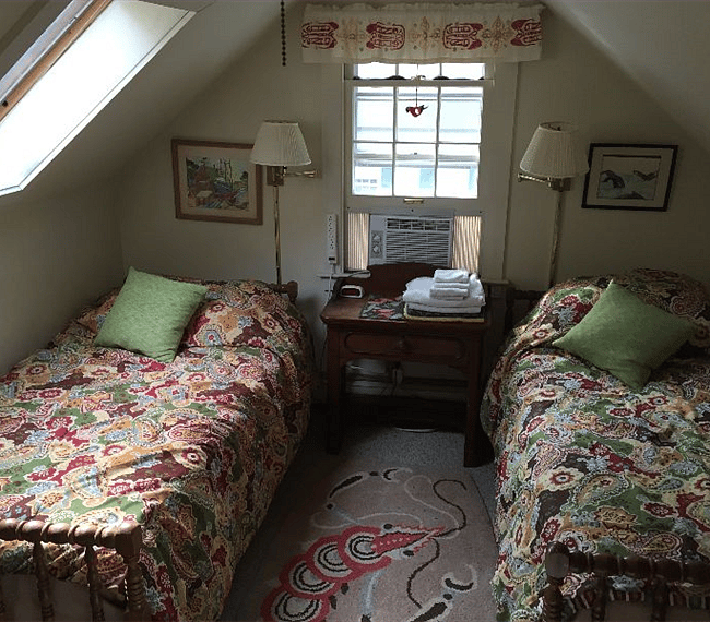 Small bedroom upstairs with two single beds.