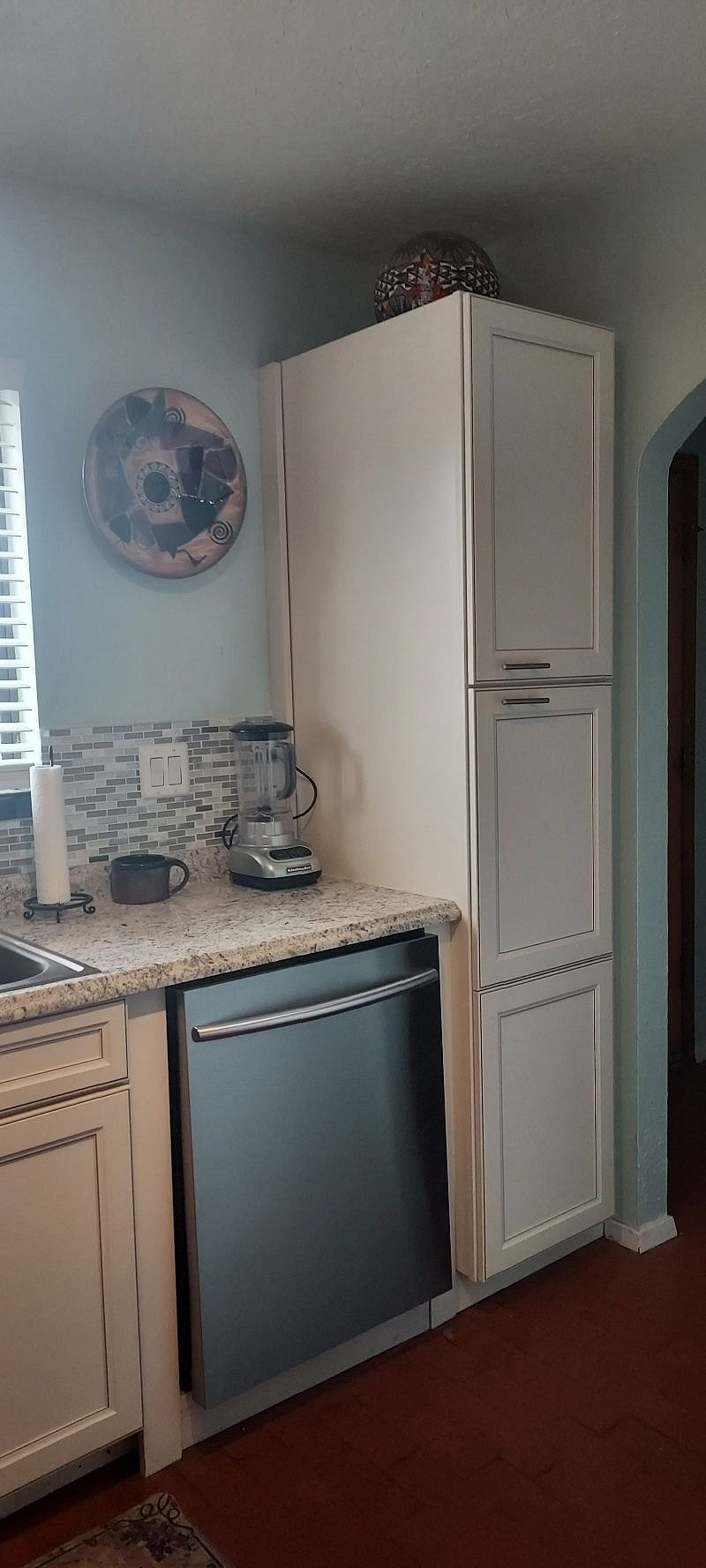 Blender near the extra large cabinet with fully loaded dishes...