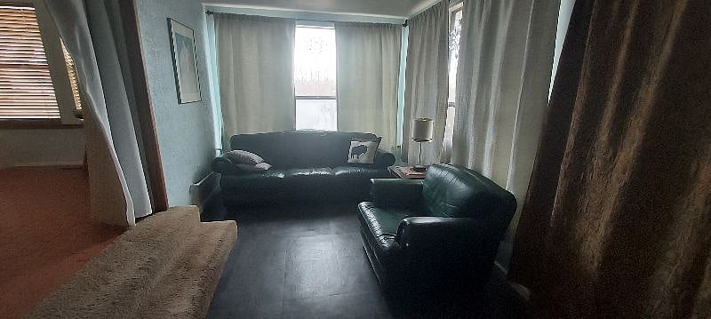 Sunroom with leather sofa/chair and office furniture. This space is perfect for reading or enjoying the beautiful views of the garden from the Inside.