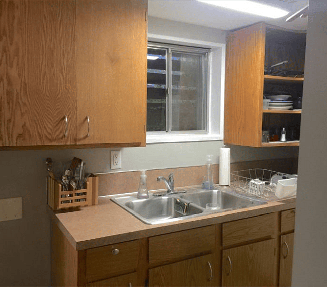 Looking into your kitchenette complete with double sink, dishes, plenty of cooking utensils.