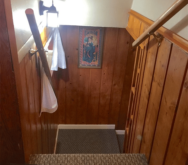 Stairs from the entrance landing down to the studio apartment.