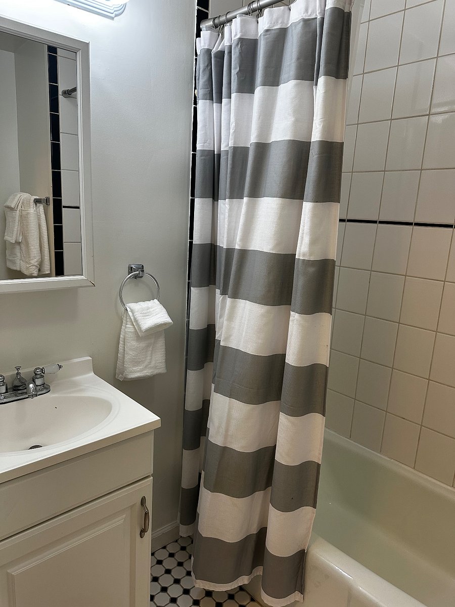 Beautiful tiled bathroom with full bath and shower.