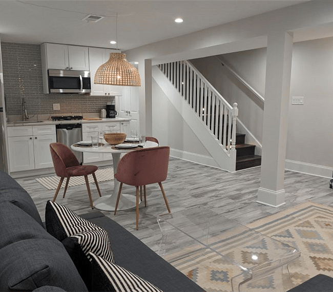 Living room, dining space, and kitchen. Stairs lead to main-level of home separated by a sound insulated door.