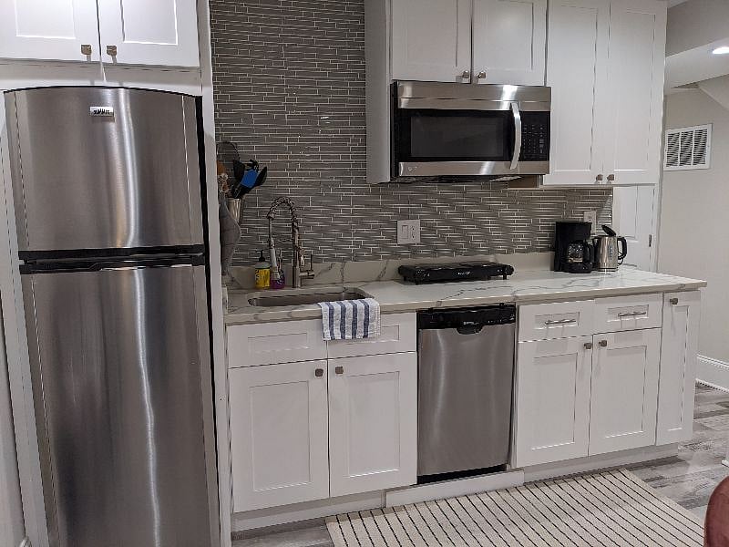 Kitchen with fridge, freezer, microwave, dishwasher, double cook top, coffee maker, kettle, disposal, and all necessary utensils.