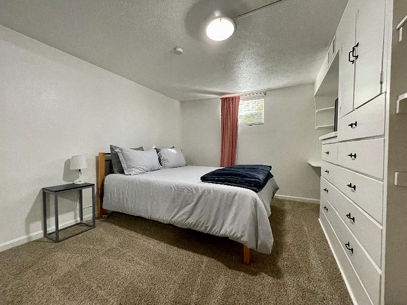 Second bedroom with queen size bed, black out curtains,  TV, and built ins for storage. 