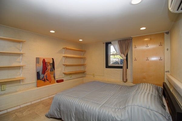 Bedroom with shelves, queen bed and large closet