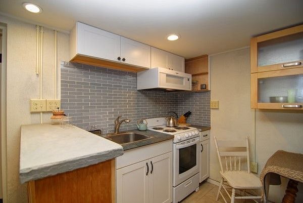 Kitchen with microwave, electric range, disposer and deep stainless sink