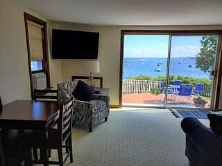 Combo living room/dining area with slider out to the back patio. Overlooks the water and Fort Constitution.