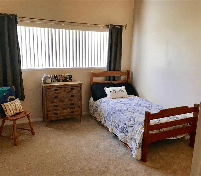 Secondary bedroom with dresser and walk in closet