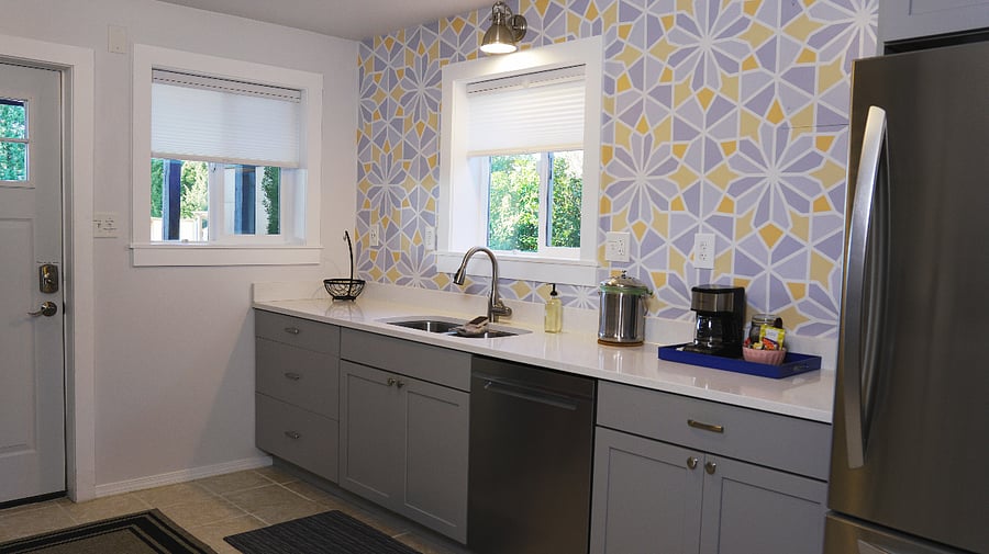 A full kitchen with a 5-burner gas stove, dishwasher, refrigerator, microwave, sink, and amenities.