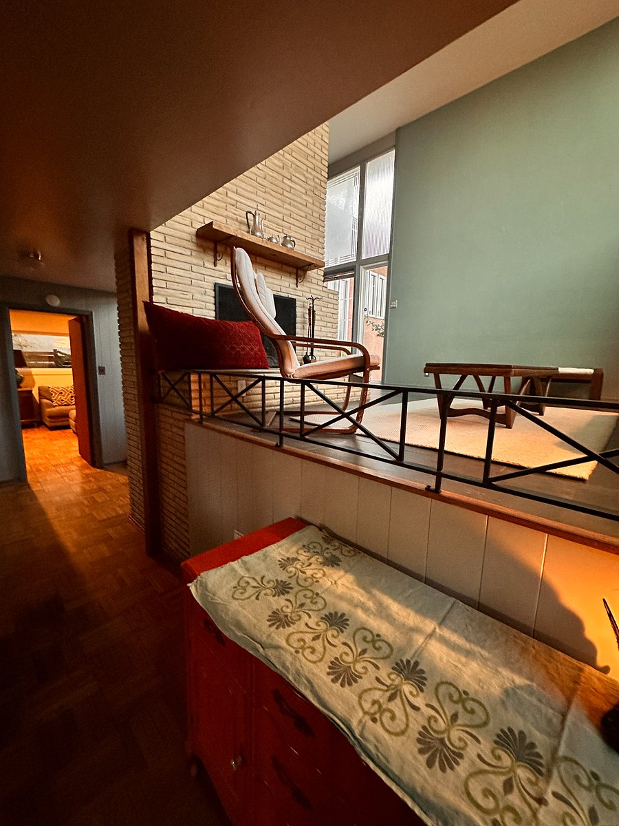 View from dining room into mid-level living room, and down the hall to the den 