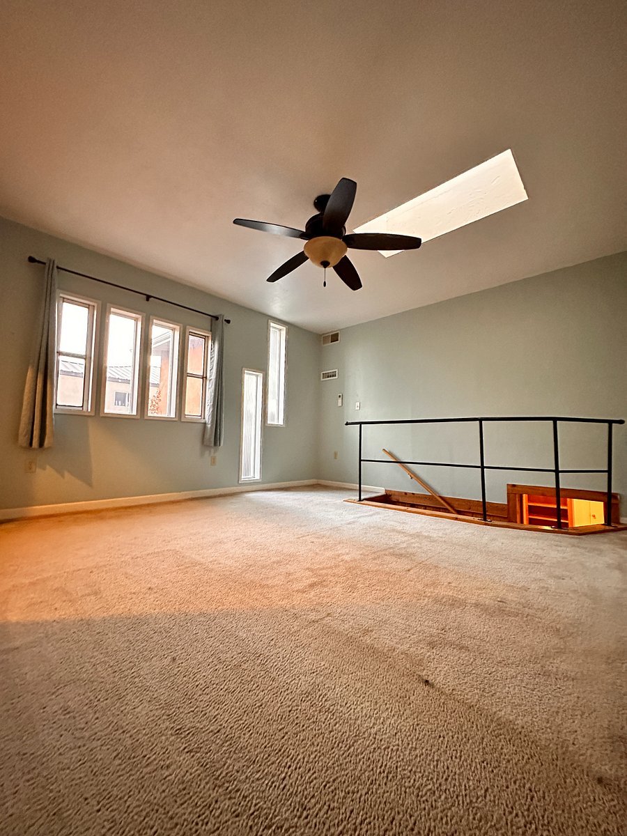View across master bedroom with skylight, toward stairway & entrance. FURNISHING UNDERWAY!