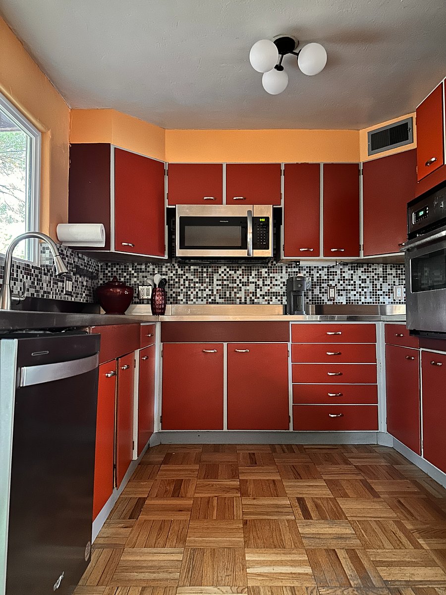 View of the kitchen from the dining room. Stainless steel appliances and countertops. 3/4 size oven. Killer 4-door fridge right of frame!