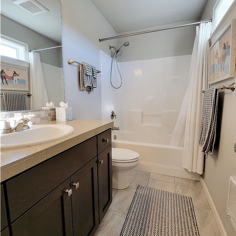 Bathroom detail, full shower and tub. Natural light.