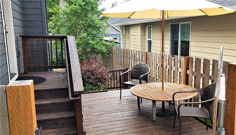 Private Patio and Entry with patio furniture and umbrella. Area is separated from the main backyard by a low fence. Ideal for a small dog.