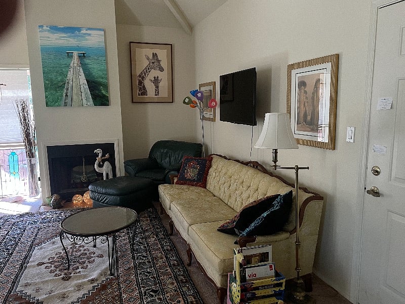 Living room, cozy chairs and sofas, floor room for exercising/yoga, tv on wall.  