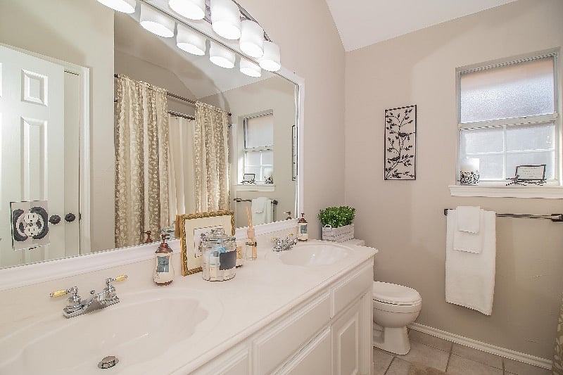 Private bath with sinks, shower/tub, and large linen closet.