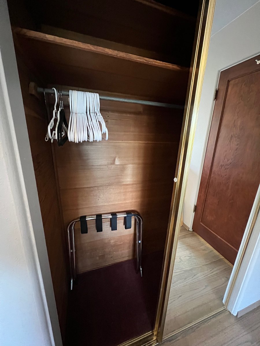 Guest closet with luggage rack, hangers and laundry basket