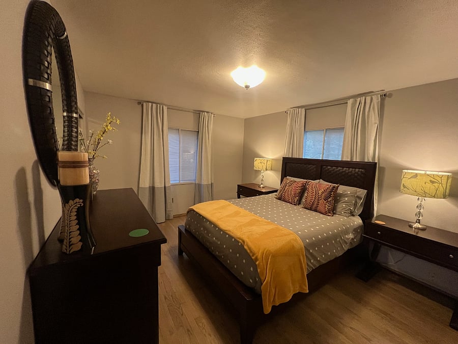 Mirrored closet, luggage rack, and six drawer dresser and large side tables.