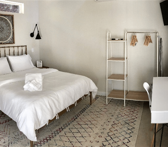 Main floor bedroom with queen size memory foam bed, working desk, TV and open closest.