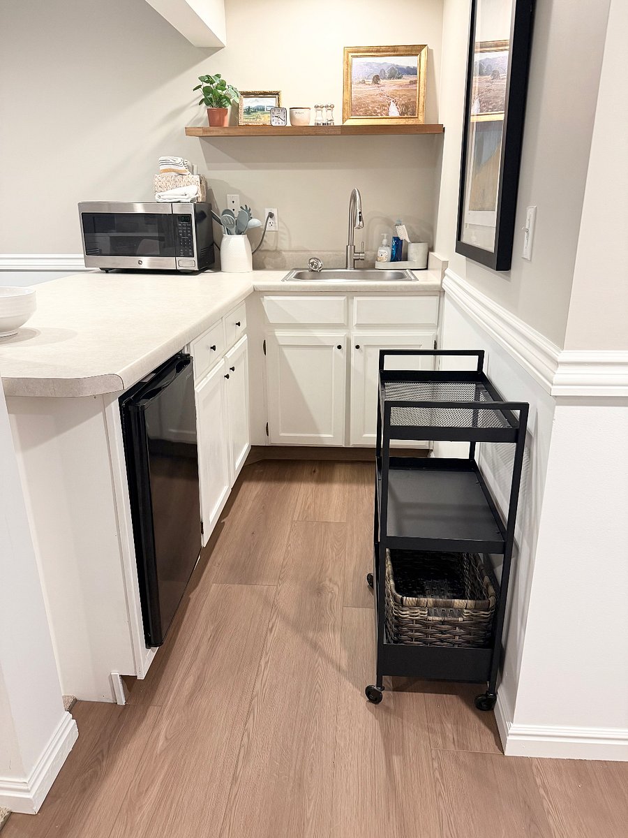 Kitchenette with fridge, hot plate, microwave and other kitchen appliances.
