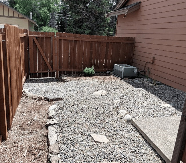 Locked side/backyard of house accessible from sliding glass doors off patio.