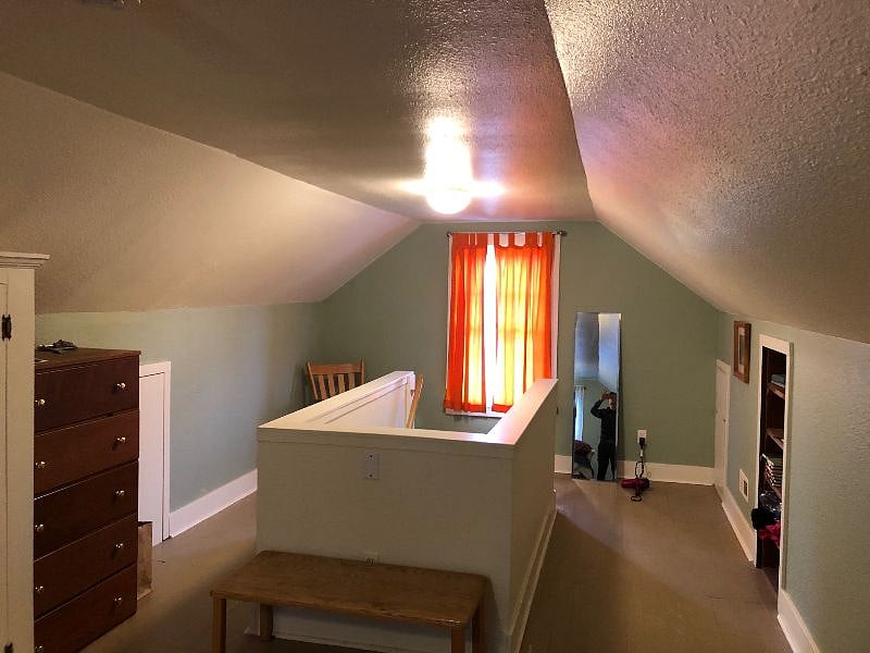 Attic bedroom with steep-ish stairs leading up. 