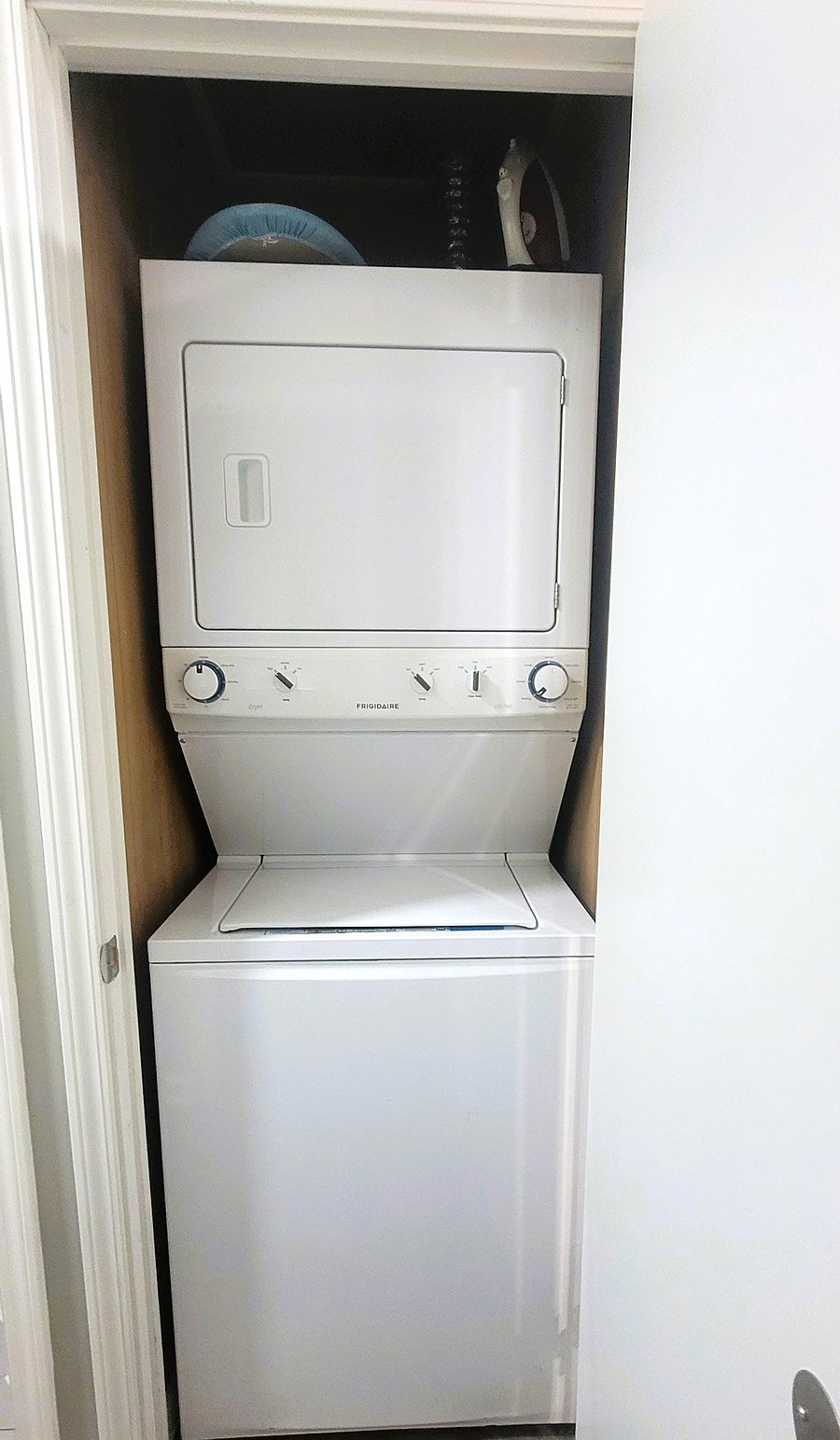 Stackable washer/dryer is located in the hall.