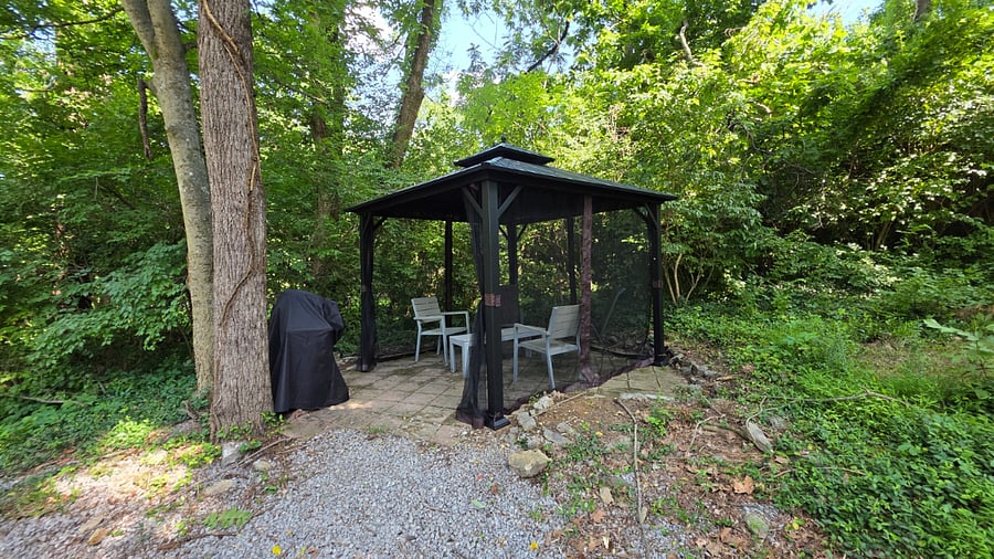 Shared, covered outdoor patio with furniture and gas grill.