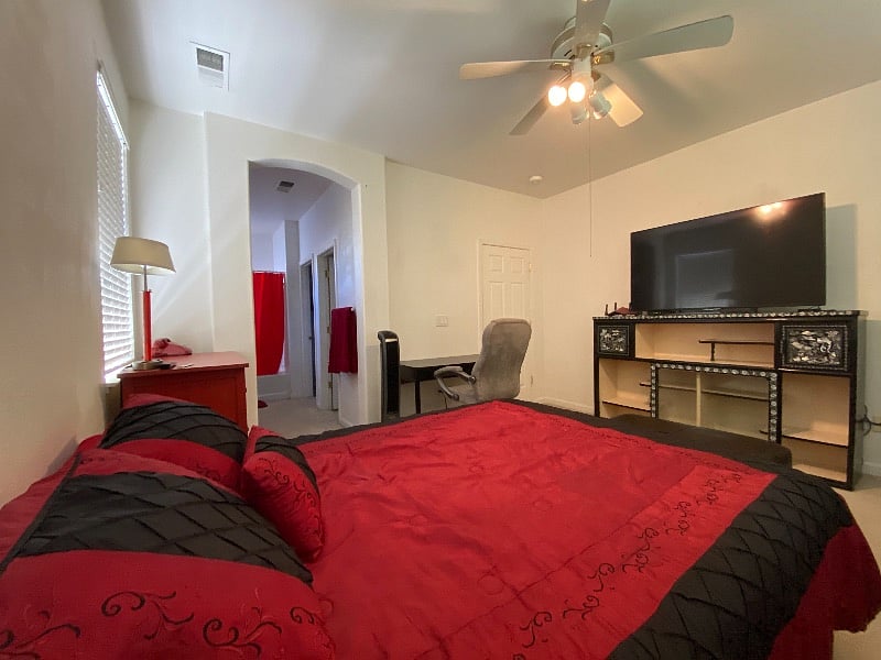 Master Bedroom with comfortable queen bed, Big-screen TV, shelves, dresser, chair, computer work station, full private bath with tub and shower, and spacious walk-in closet.