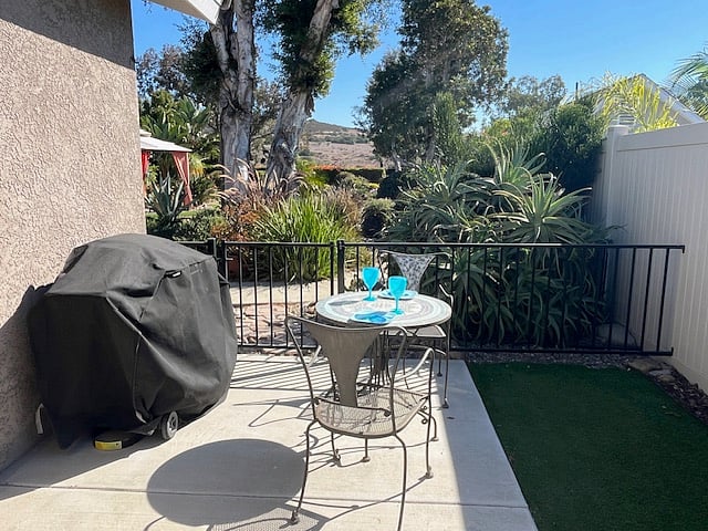 BBQ, bistro set and fence looking at view into main house yard