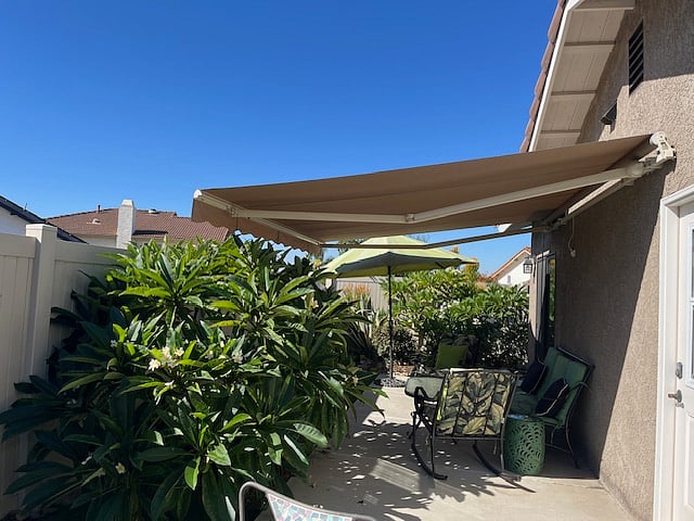Private patio with retractable awning, conversation seating and beautiful garden with plumerias