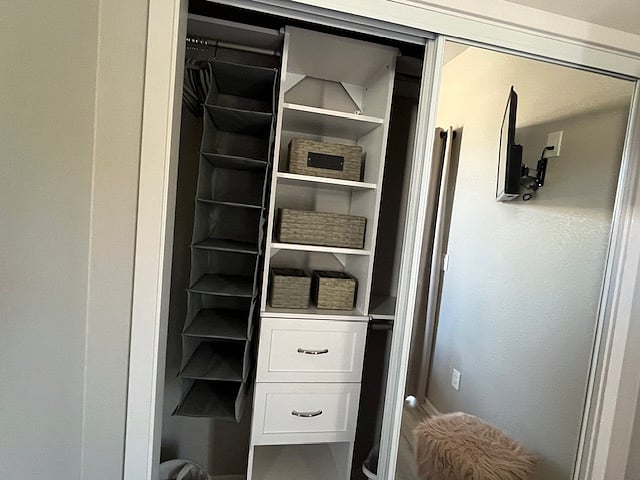 bedroom closet with mirrored doors, shelves and drawers