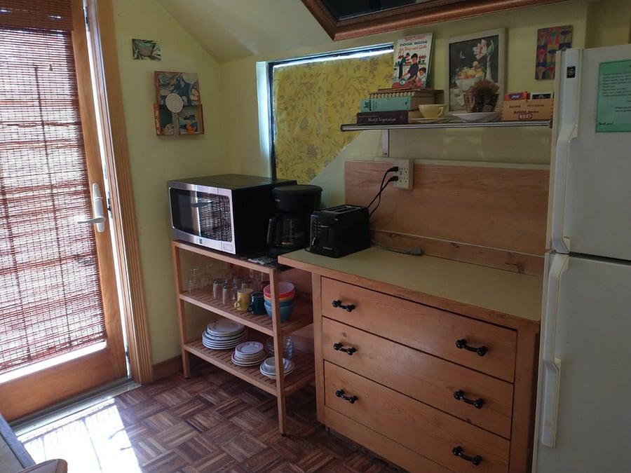 Kitchen includes dishes, microwave, toaster, coffee maker, gas stove, refrigerator.