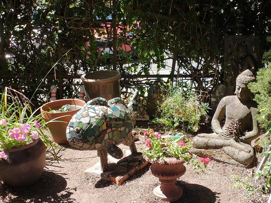 Front yard with Buddha and mosaic salmon sculpture by local artist.