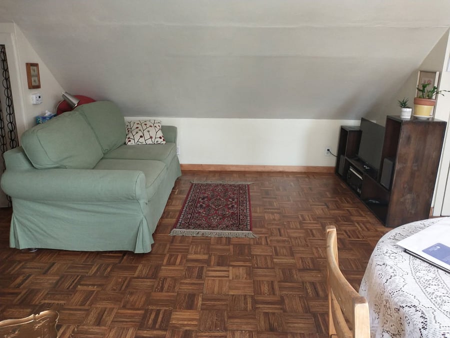 Sofa bed, smart TV, stereo, and hardwood parquet floor.