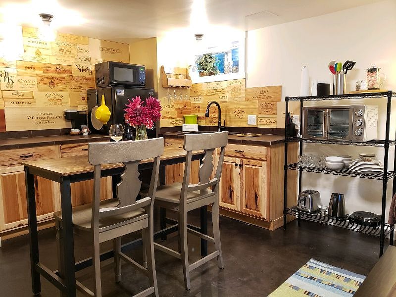 Well laid-out kitchen with ample counter surface and custom wine themed backsplash