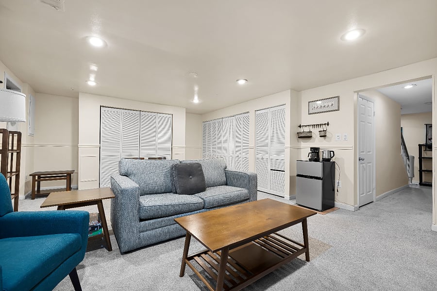 Living and dining areas. Shared laundry in closeted area on the right. Hallway for the bathroom and down to the bedroom and stairs.