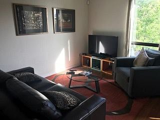 Spacious living room with TV & comfy furnitures