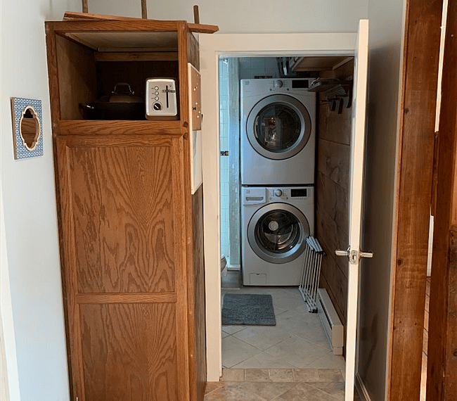Pantry and view of bathroom door with washer and drier.