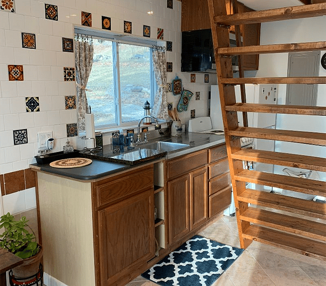 View of kitchen and stairway to sleeping loft.