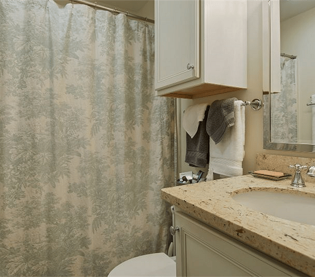 Bath features a tub/shower combo, vanity with quartz counter and ample storage